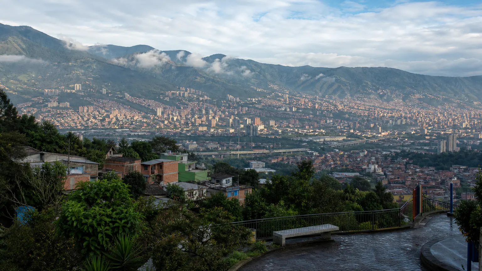 Illustration pour Medellín : panorama urbain depuis une hauteur verdoyante, face aux reliefs